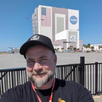 Dan Lee-Odinson at Kennedy Space Center, with the Vehicle Assembly Building behind him.
