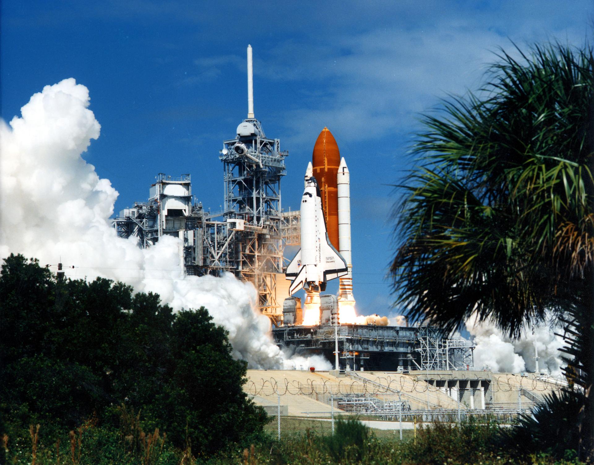 Discovery rising above Launch Pad 39B on STS-26, with bright booster exhaust and clouds of steam.